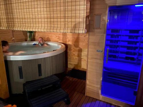 a person in a hot tub in a room at HOLTINGERHUYS Uffelte- Giethoorn! Optie Wellness!!! in Uffelte