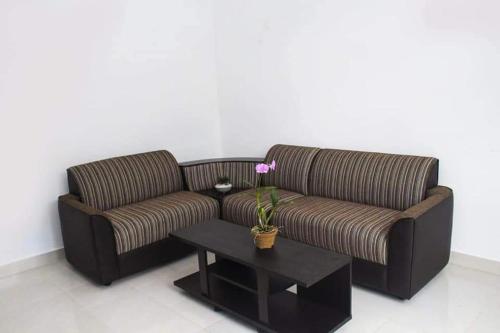 a brown couch and a coffee table in a room at Hotel Sojan in Veyangoda