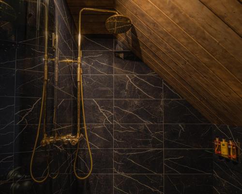 a bathroom with a shower with a black marble floor at Northern Lights Village Pyhä in Pyhätunturi