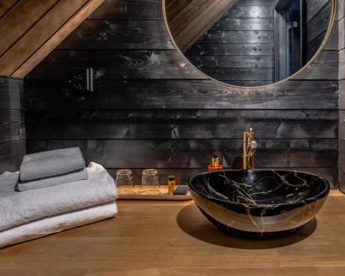 a bathroom with a black wall and a black tub at Northern Lights Village Pyhä in Pyhätunturi