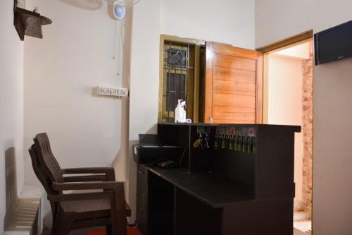 een zwart bureau met een stoel in een kamer bij Goroomgo Caroline Homestay Bhubaneswar in Bhubaneshwar