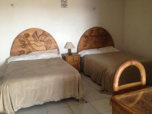 A bed or beds in a room at Hotel Colibri Queretaro