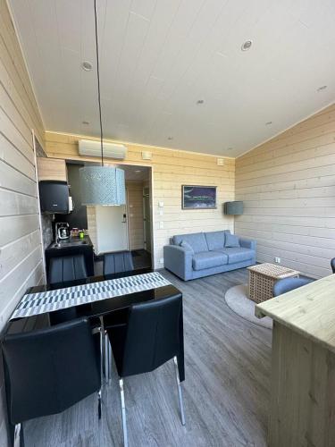 a living room with a couch and a table and chairs at Northern Lights Village Pyhä in Pyhätunturi