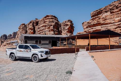 a white truck parked in front of a building at Rum Under The Stars Camp in Wadi Rum