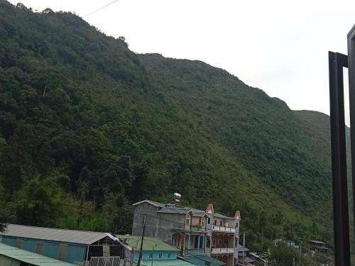 a large building in front of a mountain at New Homestay in Ha Giang