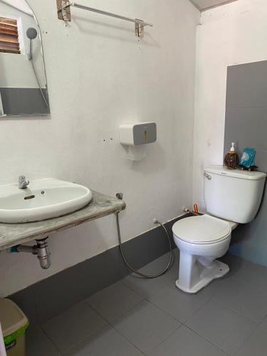 a bathroom with a white toilet and a sink at Sunrise House in Ko Yao Noi