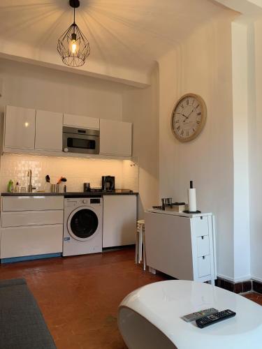 une cuisine avec une machine à laver et une horloge au mur dans l'établissement THE HEART OF CANNES 5MIN BY LA CROISETTE AND BEACH, à Cannes