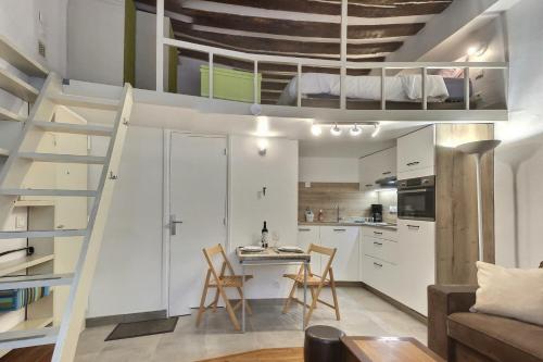 a loft apartment with a staircase and a kitchen at Le Saint Claude in Paris