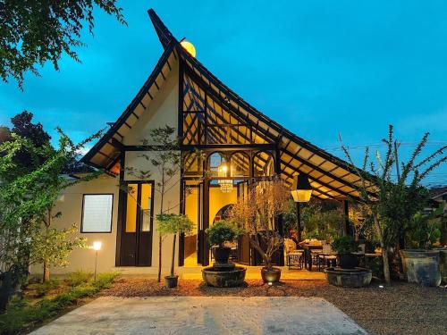 a house with a large roof with a patio at O2 The Residence โอทู เดอะ เรสซิเดนซ์ in Kanchanaburi