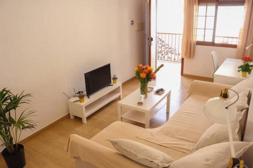 a living room with a couch and a tv at Inés (B): Relax y playa. in Breña Baja