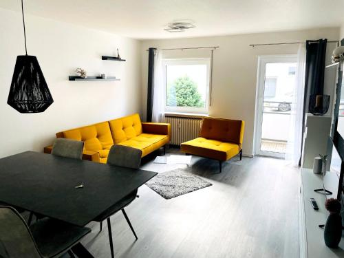- un salon avec des canapés jaunes et une table dans l'établissement Zollernalb-Apartment G6, à Albstadt