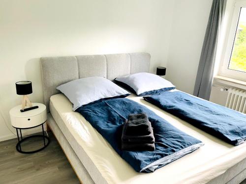 Una cama con sábanas azules y una toalla. en Zollernalb-Apartment G6 en Albstadt