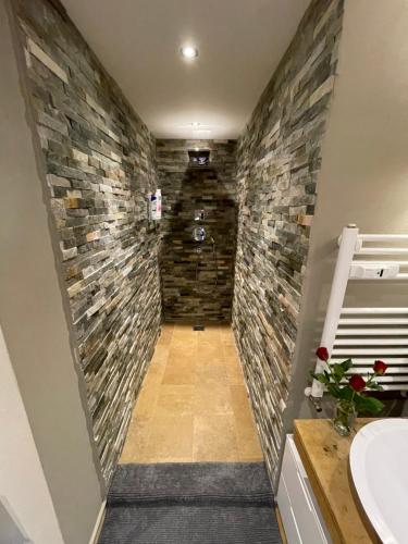 ein Badezimmer mit einer Steinmauer in der Unterkunft Luxury apartment in Crans-Montana