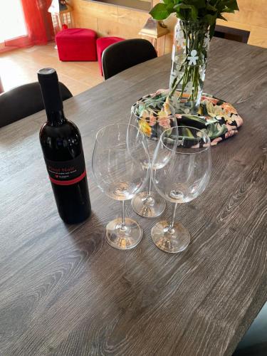 a bottle of wine and two wine glasses on a table at Luxury apartment in Crans-Montana