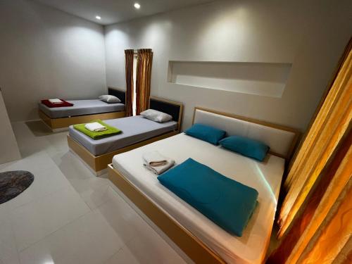 a bedroom with two beds with blue pillows at บ้านพักสิริ มุกดาหาร (Baan Siri Mukdahan) in Ban Muang Ba