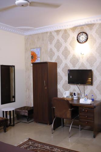 a room with a desk and a clock on a wall at Waypoint Hotel in Karachi
