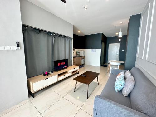 - un salon avec un canapé et une télévision dans l'établissement Manhattan Suites by NAJ, à Penampang