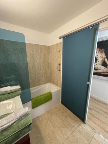 łazienka z prysznicem, wanną i drzwiami w obiekcie Monte-Carlo confortable apartment air-conditioned, beach 8 mn by foot w mieście Beausoleil