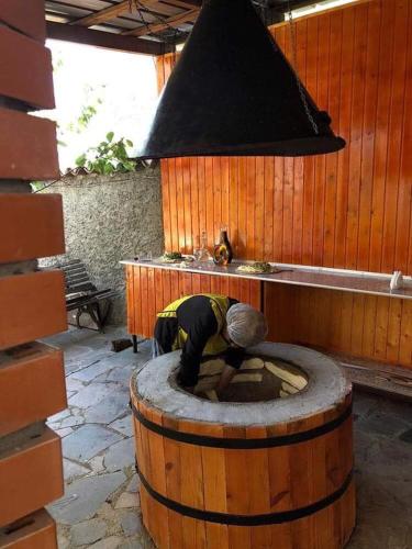 a person bending over in a barrel in a room at სასტუმრო ამელი/Hotel Ameli in Tʼelavi