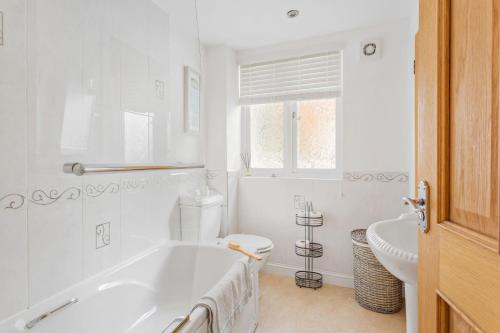 a bathroom with a tub and a toilet and a sink at 3 Bell Court - Large Apartment close to Historic Market and Quay in Dartmouth