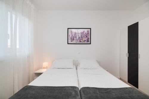 um quarto com duas camas e uma foto na parede em Villa Tonći Zaton em Zaton