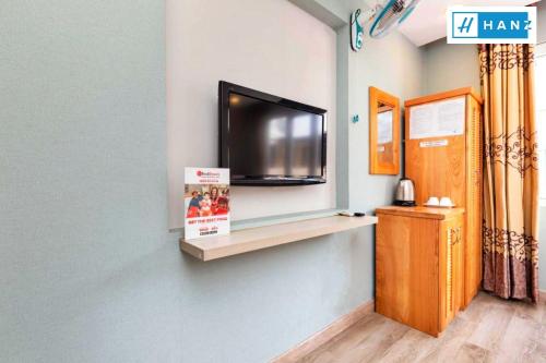 a flat screen tv on a wall with a shelf at Luan Vu Hotel in Ho Chi Minh City