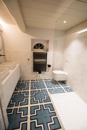a bathroom with a blue and white tile floor at Friesenhaus am See in Aventoft