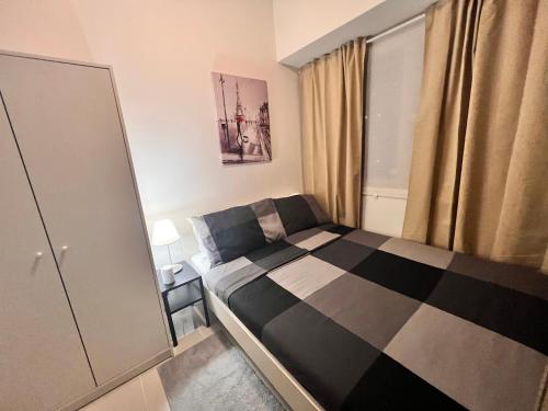 a bedroom with a black and white checkered bed at SMDC Coast Residences in Manila