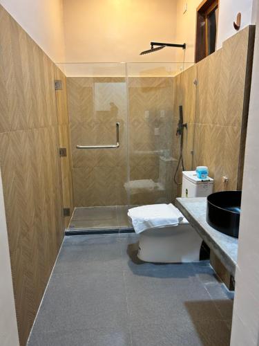 a bathroom with a shower with a toilet and a sink at Yapak Beach Villas in San Isidro