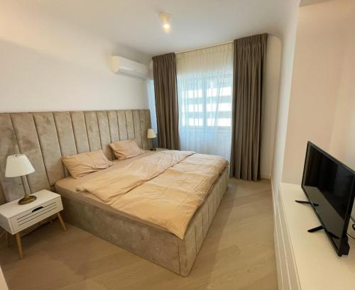 a bedroom with a bed and a flat screen tv at Luxury Wellness&Spa- Cortina North in Bucharest