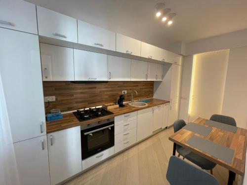 a kitchen with white cabinets and a table and a dining room at Luxury Wellness&Spa in Bucharest