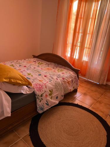 un letto con piumone e tappeto in una camera da letto di Kaz Zézère ô coeur du Bras Creux Tampon a Le Tampon