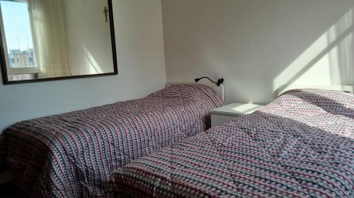 um quarto com 2 camas e um espelho na parede em Casa Parco Leati em Ferrara