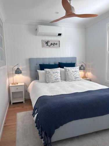 Catherine Hill Bay的住宿－Bluemoon Getaway，一间卧室配有一张大床和蓝色床头板