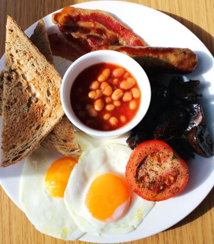 a plate of breakfast food with eggs bacon beans and toast at Victoria Square Hotel Clifton Village in Bristol