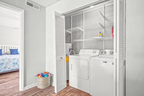 a white laundry room with a washer and dryer at 2nd Row Beach Condo, steps to the beach, with Pool in Myrtle Beach