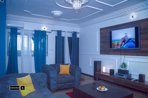 een woonkamer met een bank en een flatscreen-tv bij CloudHill in Buea