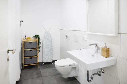 a white bathroom with a toilet and a sink at IDEE living:Loft-Apartment bei Heidelberg in Dossenheim