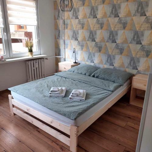 a bedroom with a bed with two towels on it at Apartament na Reja in Olkusz