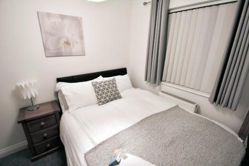 a small bedroom with a bed and a window at Mill Lane Refurbished 2 Bedroom Apartment in Newbury