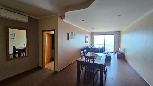 a living room with a table and chairs and a dining room at Ocean Breeze Apartment in São Vicente