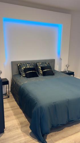 a large bed in a bedroom with a blue at Maison jardin paisible 1 chambre in Mérignac