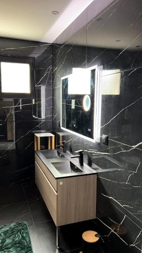 a black bathroom with a sink and a mirror at Maison jardin paisible 1 chambre in Mérignac