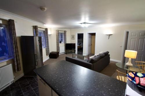 a living room with a couch and a table at Mill Lane Refurbished 2 Bedroom Apartment in Newbury