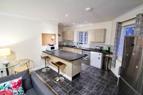 a living room with a couch and a kitchen at Mill Lane Refurbished 2 Bedroom Apartment in Newbury