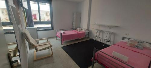 a small room with two beds and a window at Coordenadas Ibiza in Ibiza Town