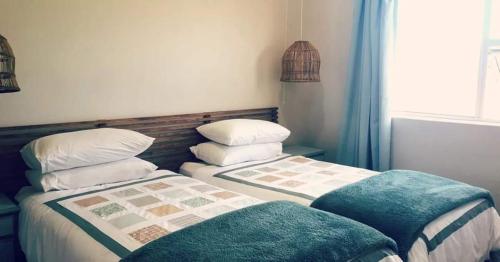 two beds sitting next to each other in a room at Secrets 2 at Waterkant 7 in Jeffreys Bay