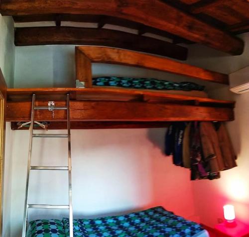 two bunk beds in a room with a ladder at The house in the paradise of Serra. in Chiusi della Verna