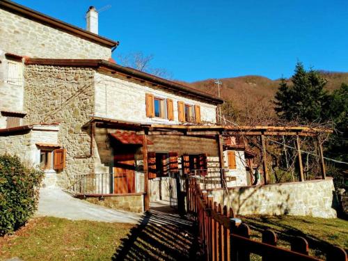 an old stone house with a fence in front of it at The house in the paradise of Serra. in Chiusi della Verna