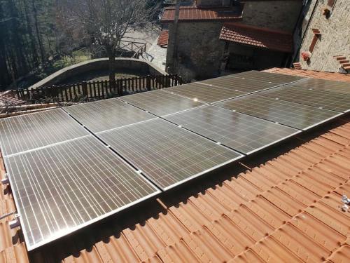 a group of solar panels on top of a roof at The house in the paradise of Serra. in Chiusi della Verna